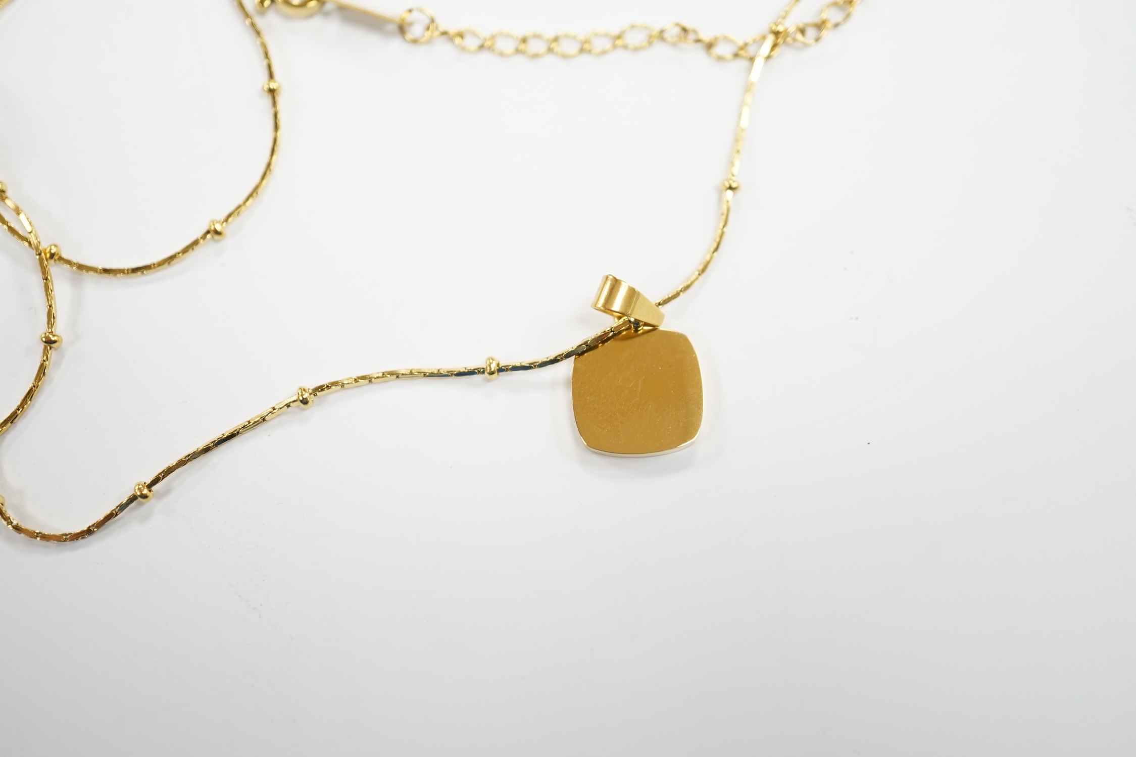 A yellow metal and mother of pearl inset pendant, 11mm on a 18kt fine link chain, 42cm, gross weight 3.4 grams.